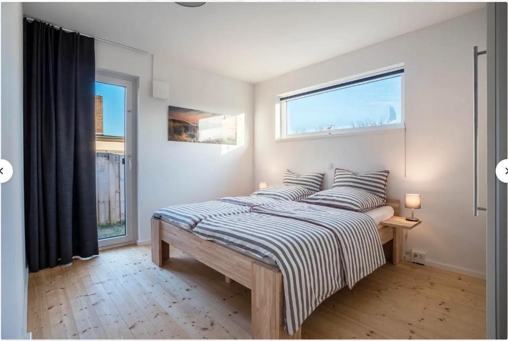 Schlafzimmer im Ferienhaus mit Doppelbett und Tür zur Terrasse