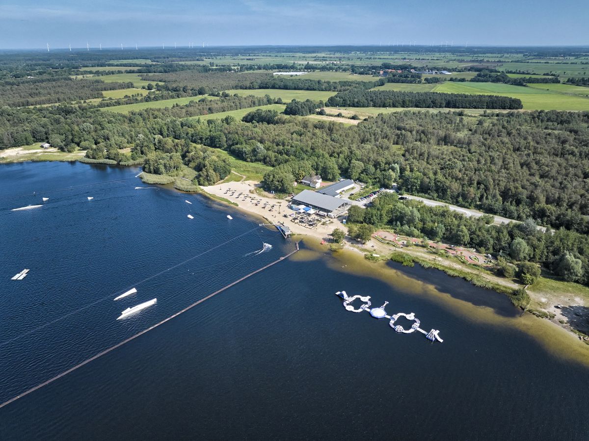 Luftaufnahme des Spadener Sees mit Wasserski-Anlage, Aquapark, Badestrand und Seeterrassen von Blue Bay